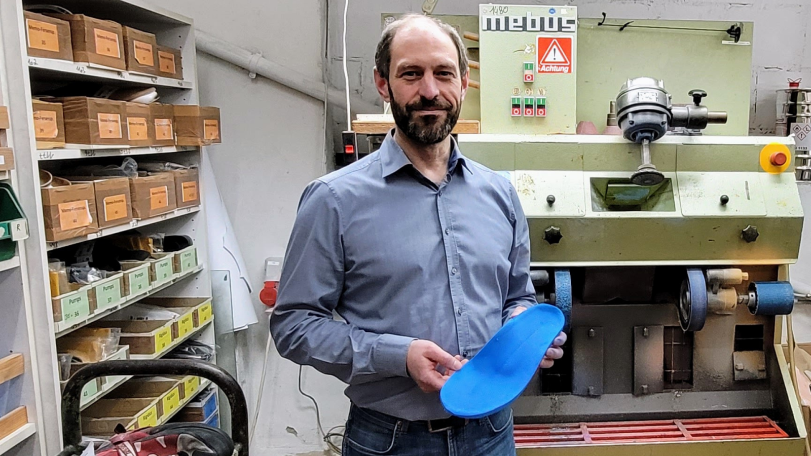 Johann Herges steht in seiner Werkstatt mit einer gefrästen orthopädische Schuheinlagen.